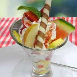 Bunter Früchtebecher mit gemischtem Eis, Früchten und Sahne.